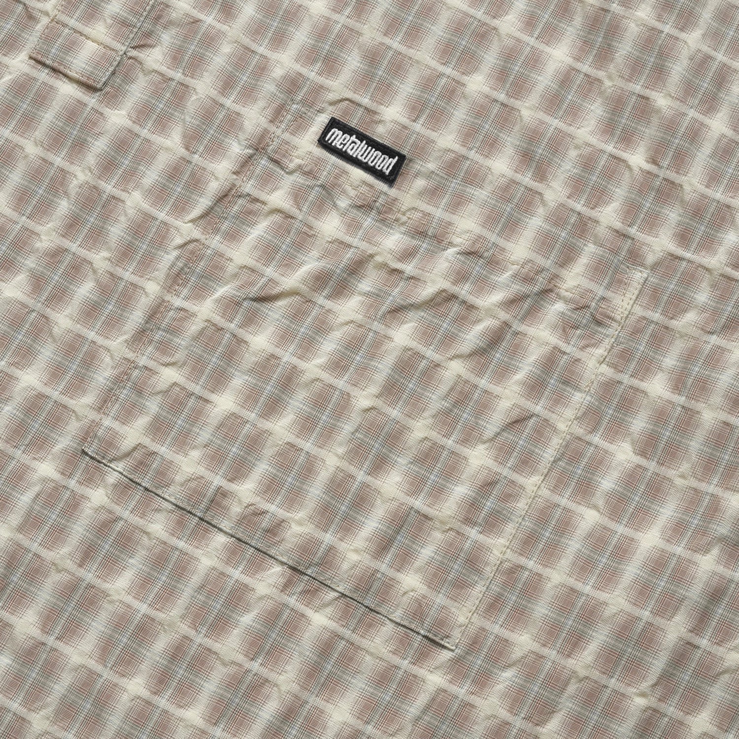 Close up of Plaid Metalwood Studio short-sleeve polo shirt on a white background