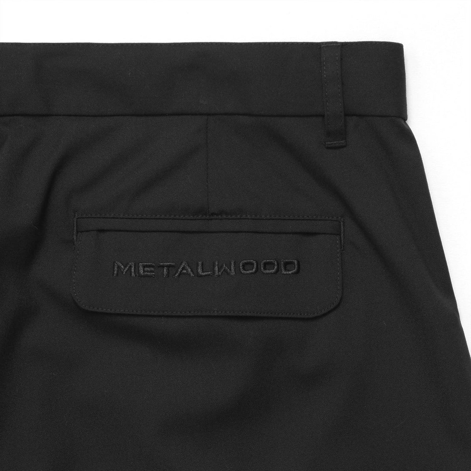 Close up of Black Metalwood Studios Trophy pants back flap pocket on a white background