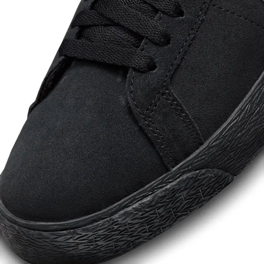Toe box of Nike SB Zoom Blazer Mid shoe in black with white Nike Swoosh logo on the side and a black sole on a white background.