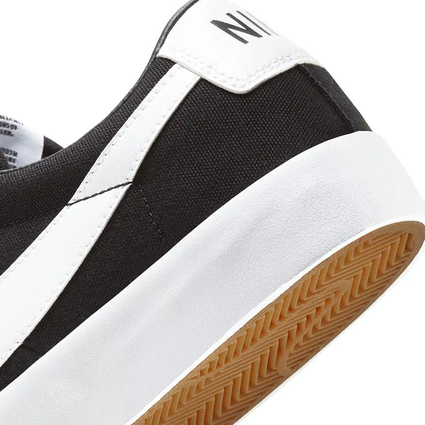 Close up of the heel of a Nike SB Zoom Blazer Low Pro GT Shoe in black and white color scheme with the Nike logo visible on the side on white background.