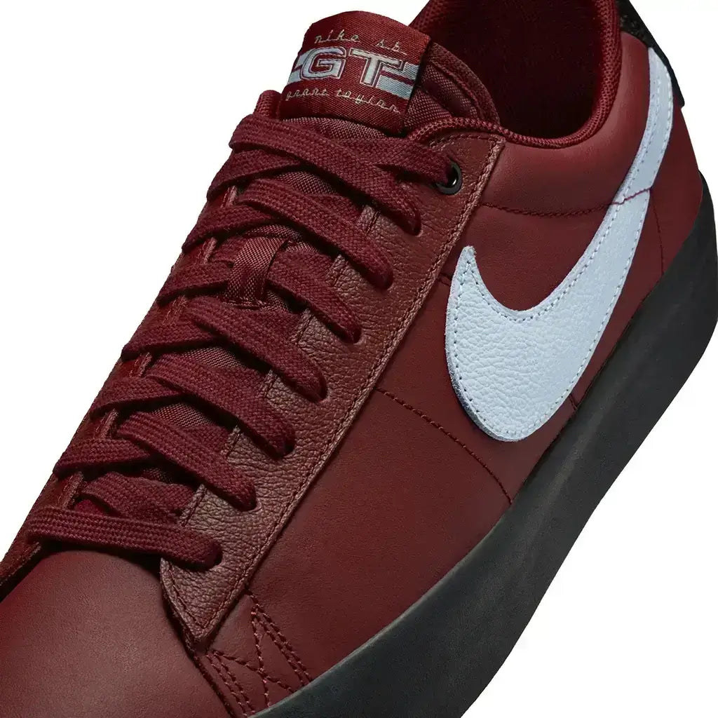 Close up of the toe of a Nike SB Zoom Blazer Low Pro GT Shoe in team red and light blue color scheme on white background.
