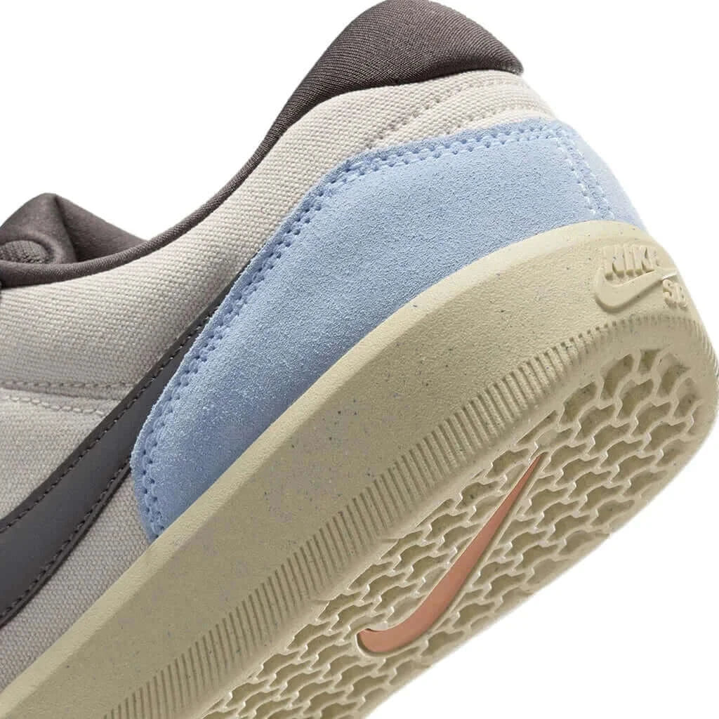 Close-up of Nike SB Force 58 shoe's heel, showcasing gray and blue accents with durable cupsole design.