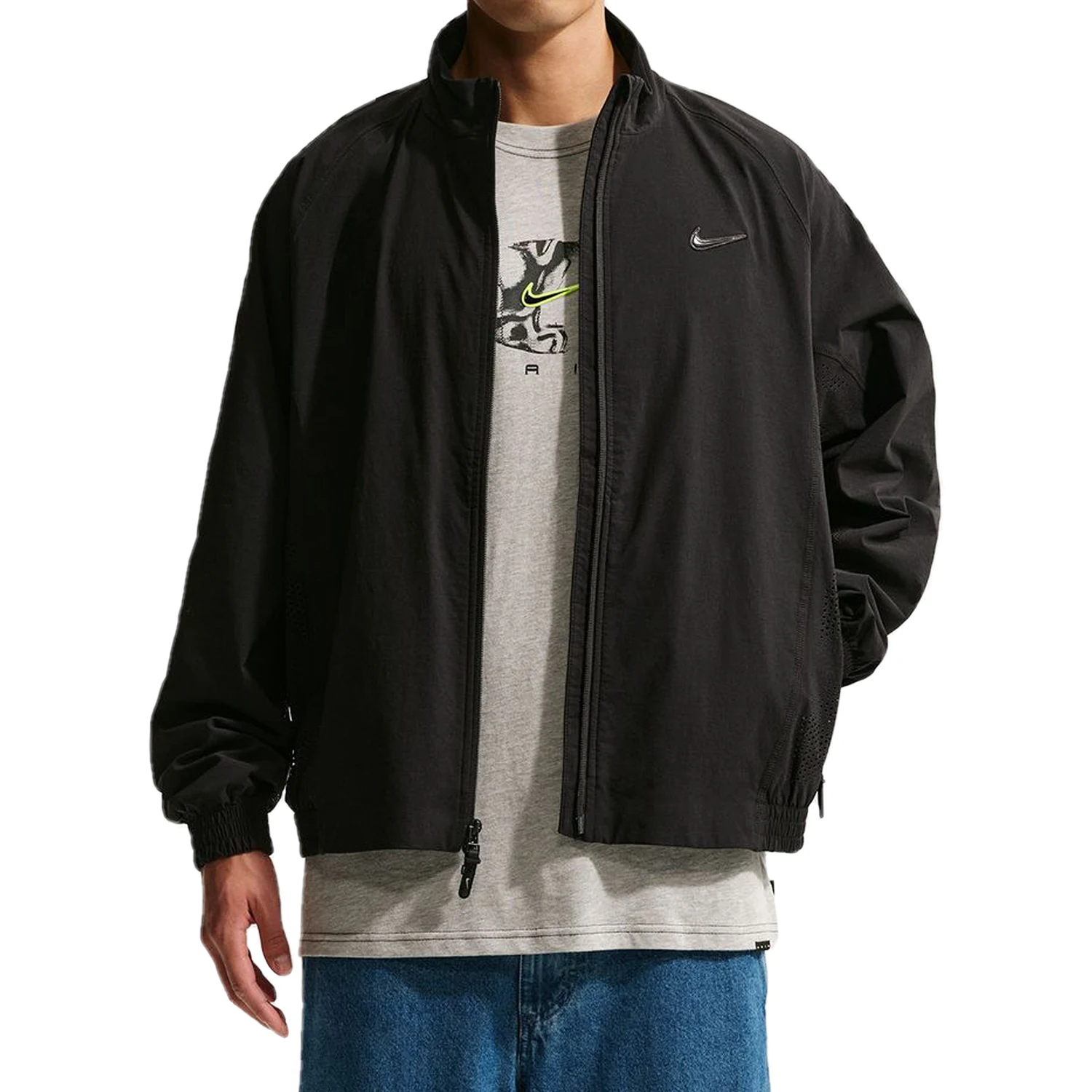 Person wearing a black Nike SB Ishod Wair track jacket over a gray t-shirt with a Nike logo on a white background