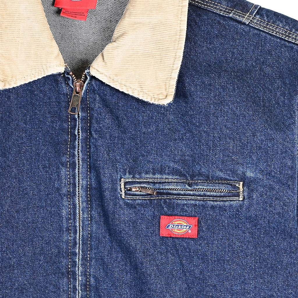 Close-up of a Dickies blue denim jacket with a beige corduroy lining and Dickies logo.
