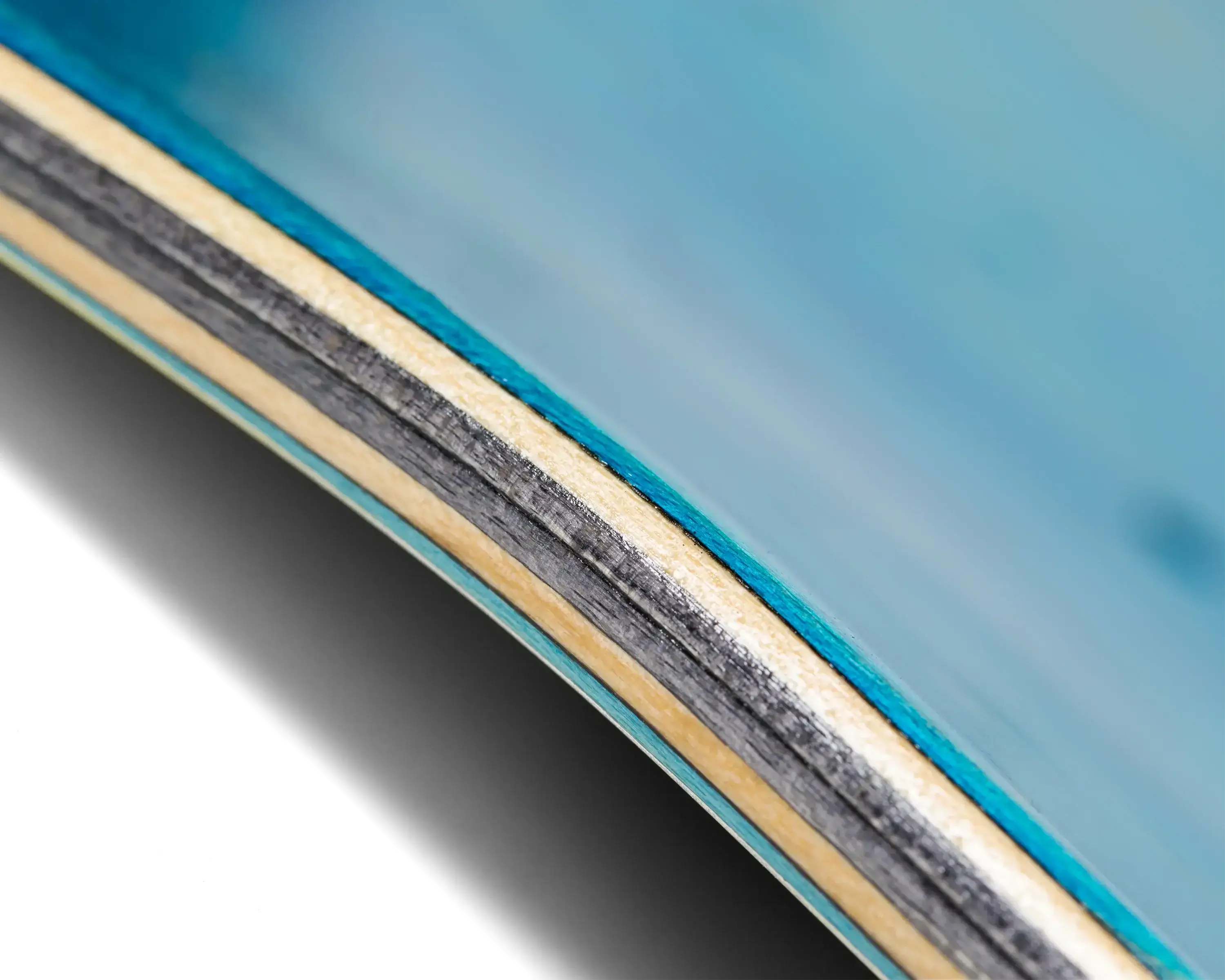 Close-up view of the Anti Hero DBX Eagle Skateboard deck edge, showcasing its classic blue veneer layers.