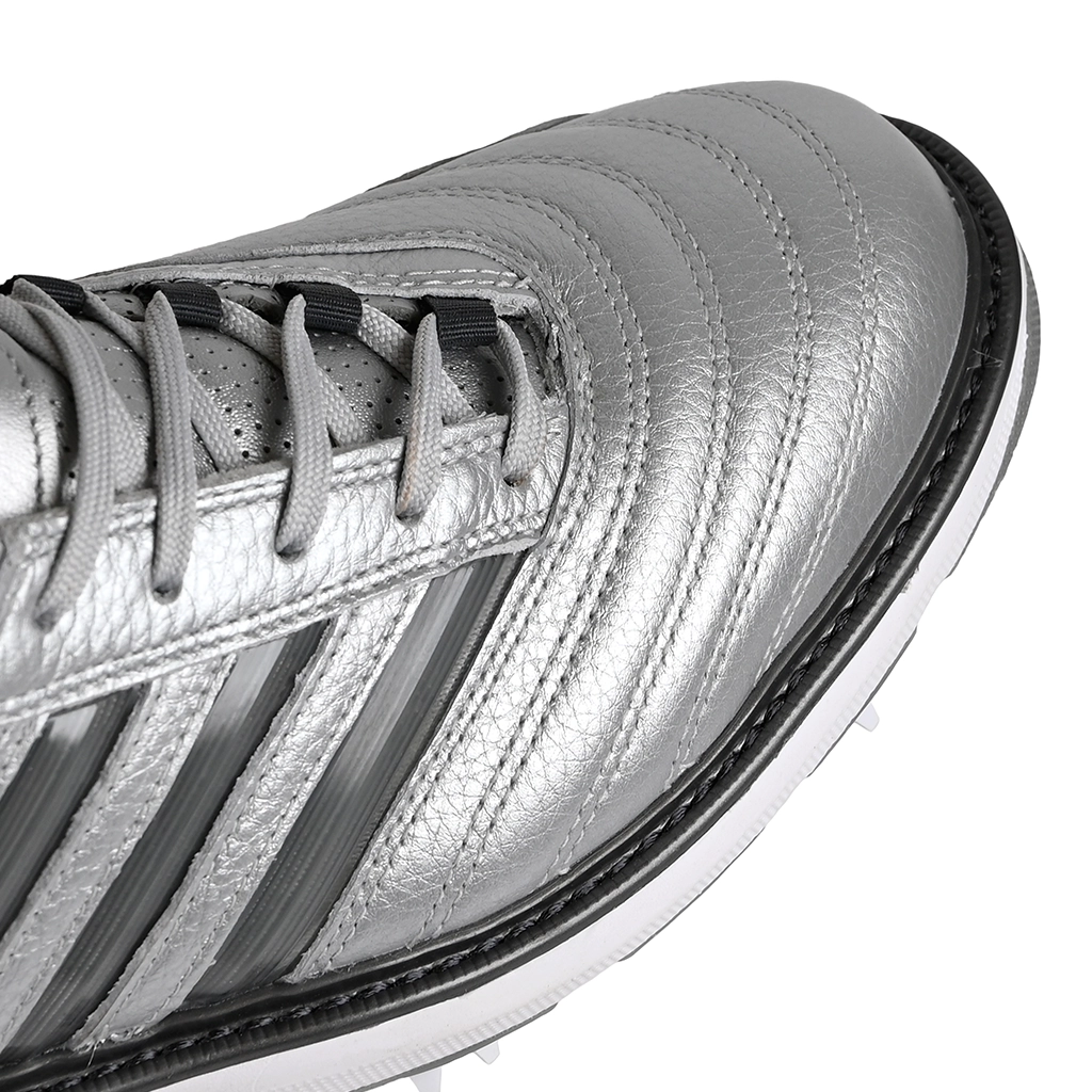 A close up of silver metallic Adidas x Metalwood MC70 golf shoe with gray stripes on a white background