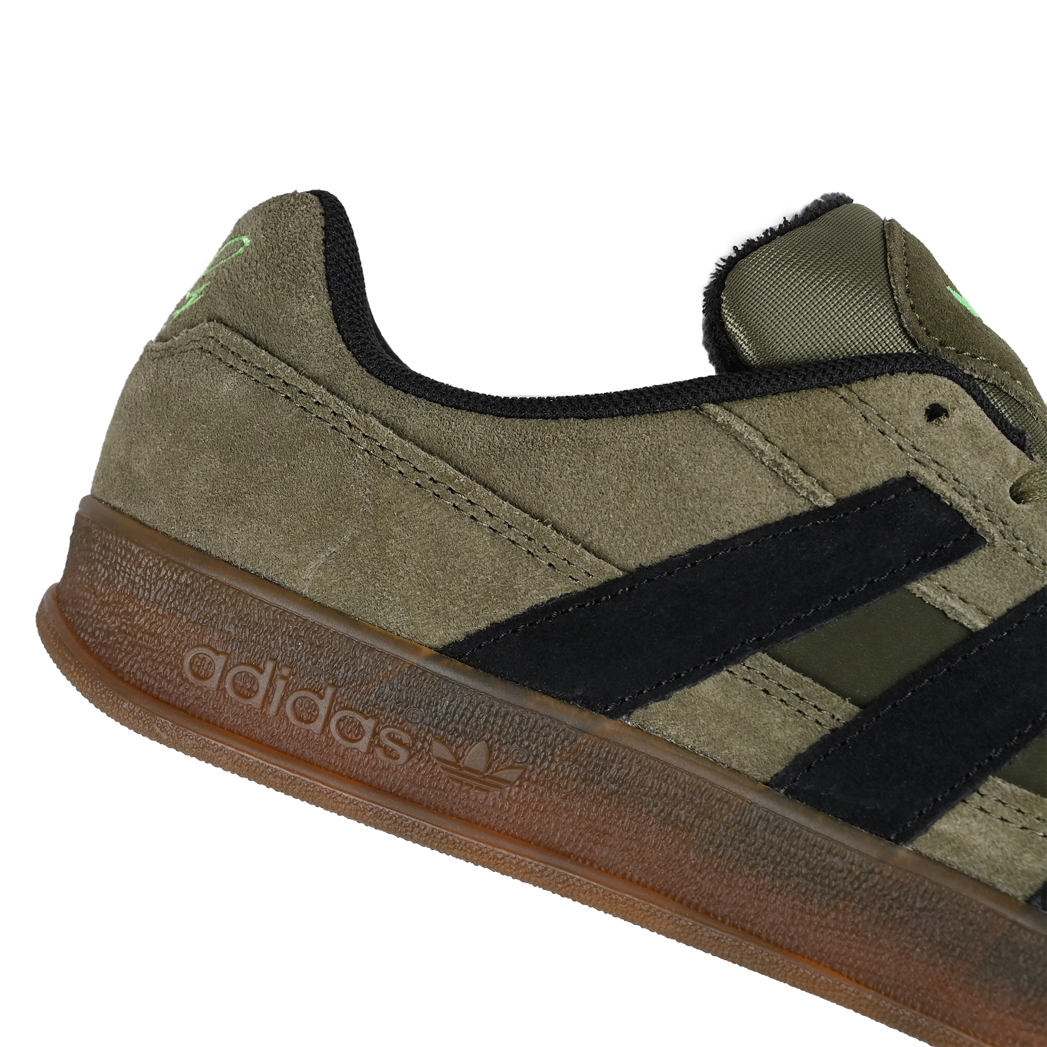 Close up of Olive Strata adidas Skateboarding Mark Gonzales pro model Aloha Super skateboard sneaker with core black stripes on a white background