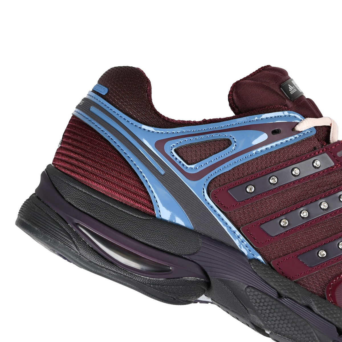 A close-up view of the heel of an Aurora Ruby adidas Skateboarding x Hardies NYC Adistar Control 5 men's sneaker on a white background