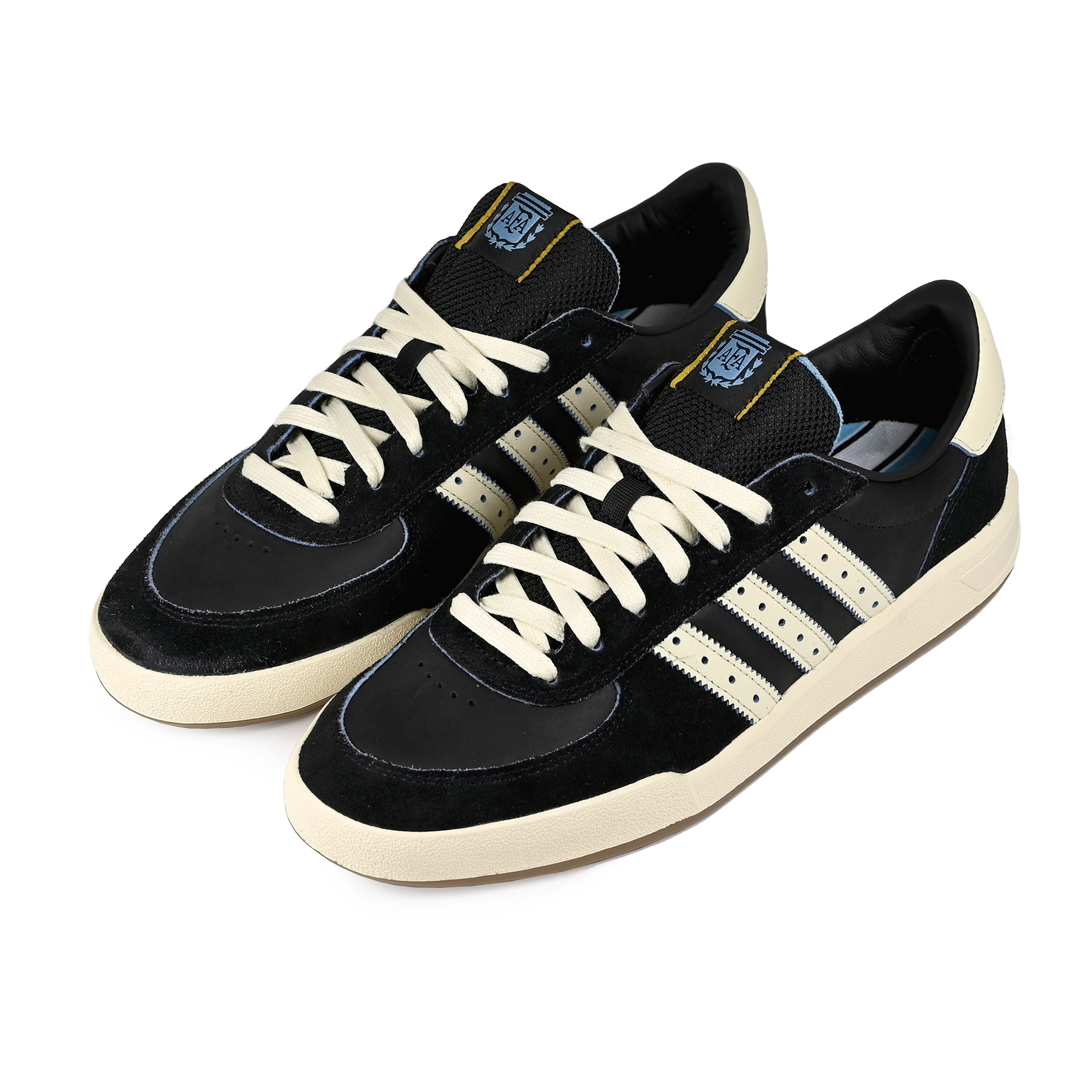 A pair of Core black and cream white adidas Skateboarding x Thrasher Magazine x Argentina Football Association Glenburn skateboard sneakers on a white background