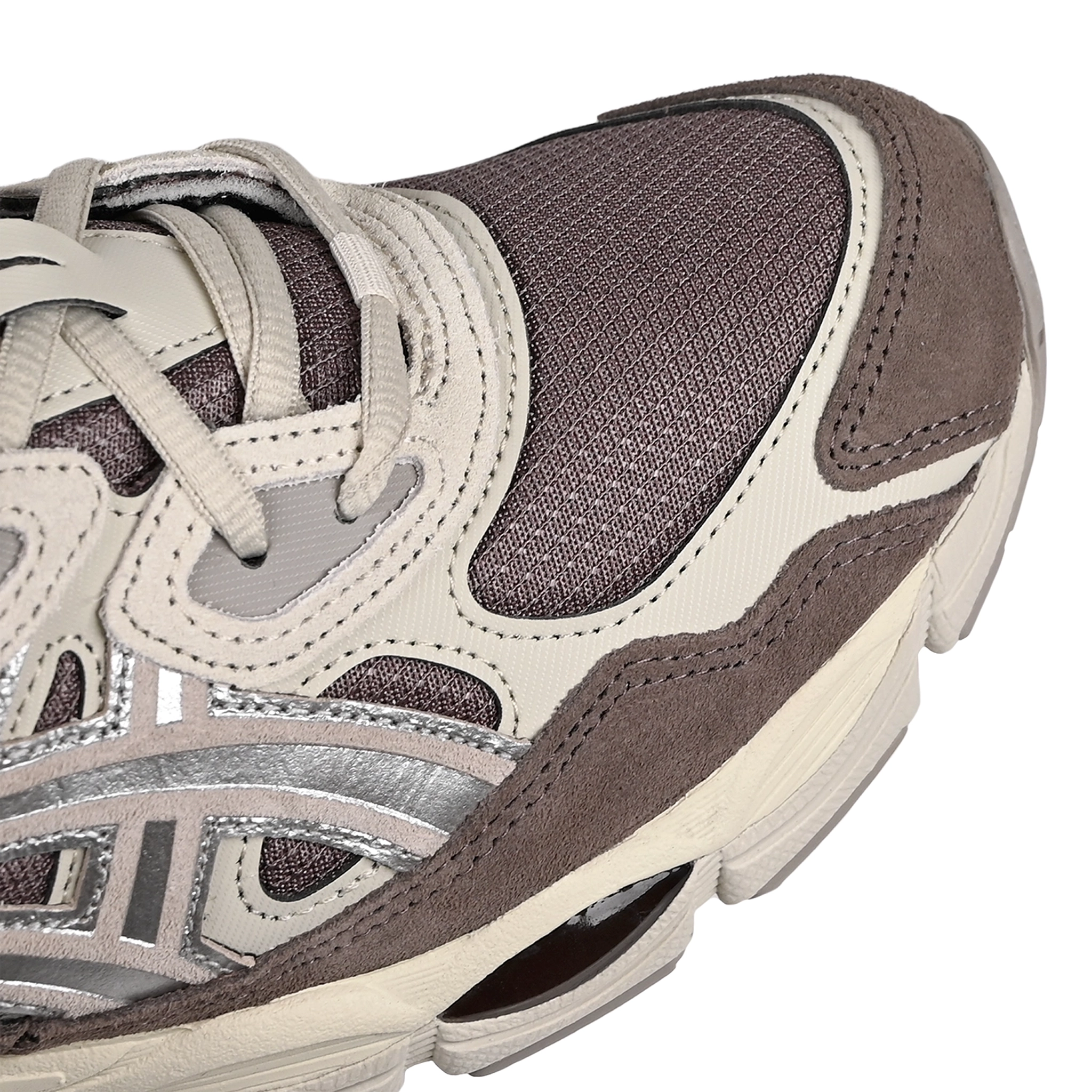 Toe box of Cocoa brown ASICS GEL-NYC sportstyle sneaker with silver 'Onitsuka' branding on a white background