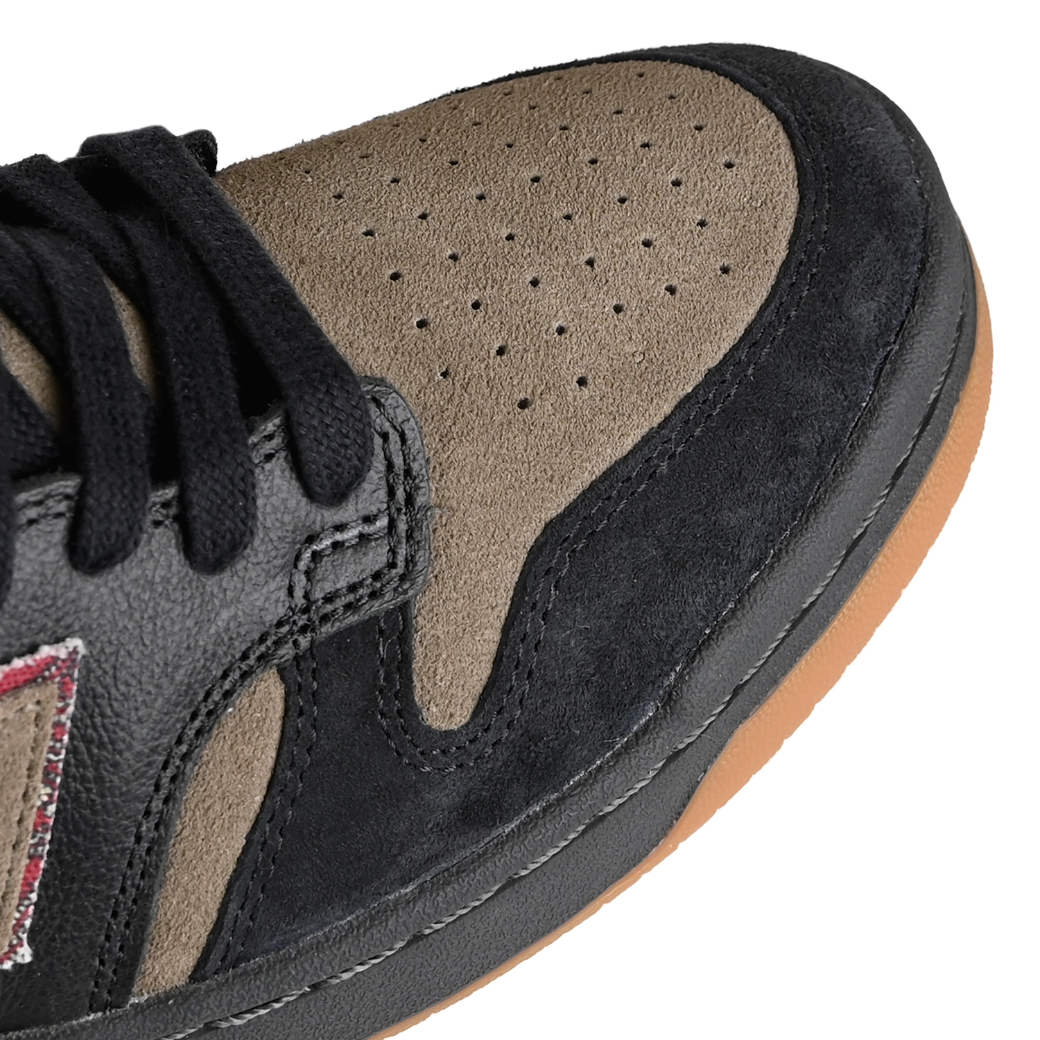 Toe box of Black and arid stone New Balance Numeric x No-Comply NM480 skateboard sneaker on a white background