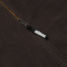Close-up of a textured brown dijon vest with a zipper and 'Metalwood' brand logo.