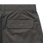 Close up of Olive Metalwood Studio Trophy Shorts with a brand label the back pocket on a white background