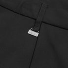 Close up of Black Metalwood Studios Trophy pants metal belt loop charm.