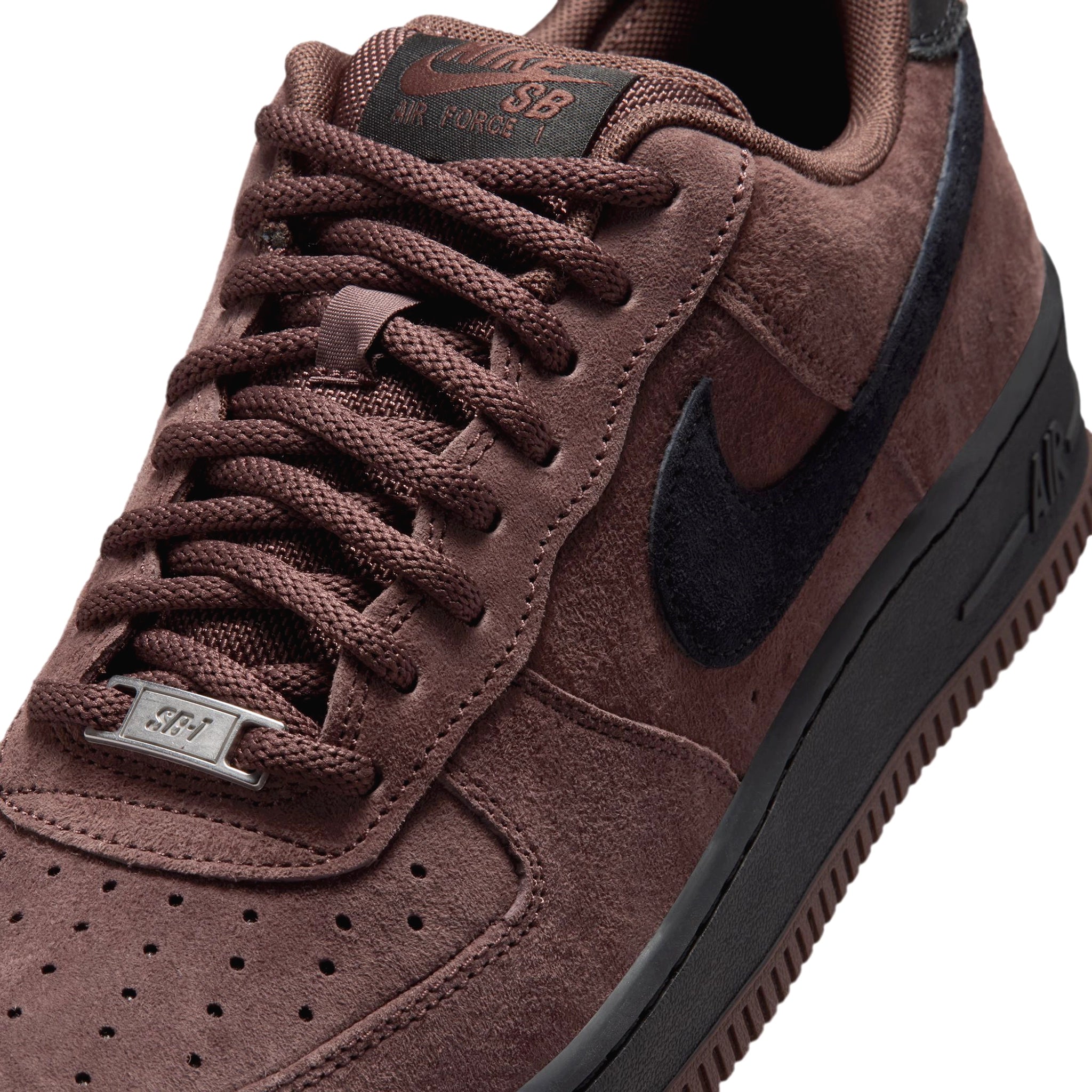 Front of a Chocolate Brown suede Nike SB Air Force One skateboard sneaker with black sole and black swoosh branding on a white background