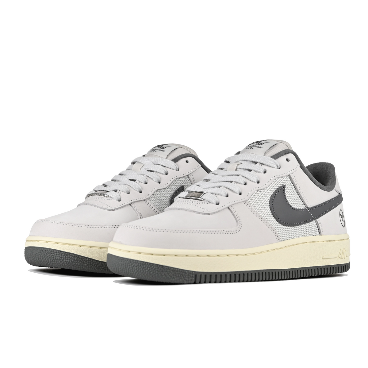 A pair of White leather and mesh Nike SB x Yuto Horigome Air Force 1 skateboard sneakers with iron grey swoosh and family crest on a white background