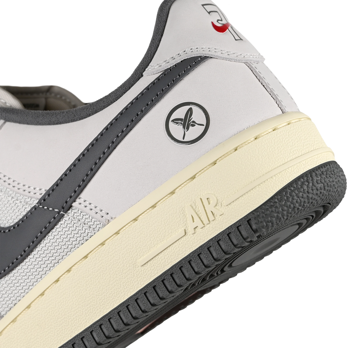 Heel of White leather and mesh Nike SB x Yuto Horigome Air Force 1 skateboard sneaker with iron grey swoosh and family crest on a white background