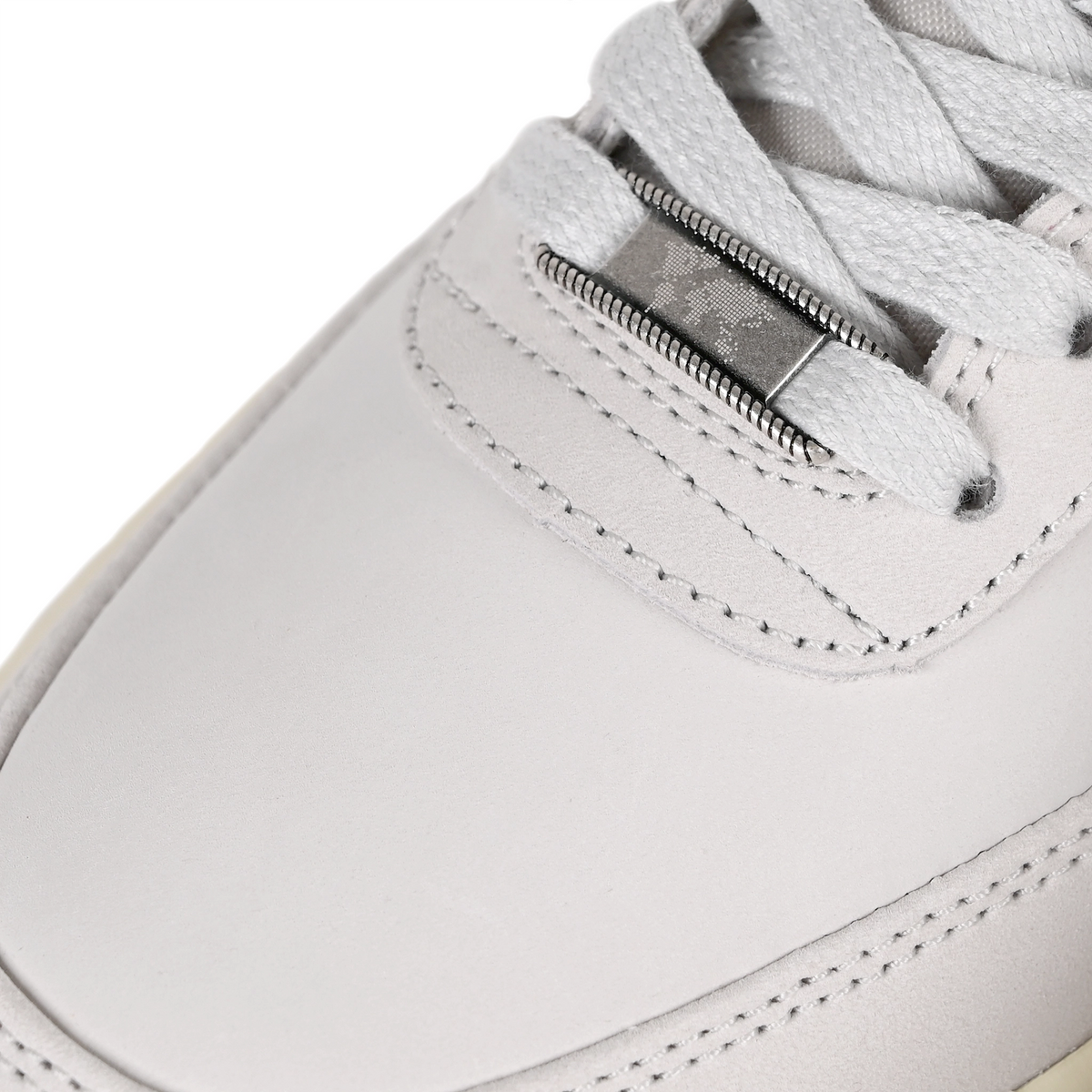 Toe box of White leather and mesh Nike SB x Yuto Horigome Air Force 1 skateboard sneaker with iron grey swoosh and family crest on a white background