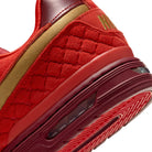 Close-up of a Nike SB P-Rod 1 red sneaker with textured sole and gold accents on a white background