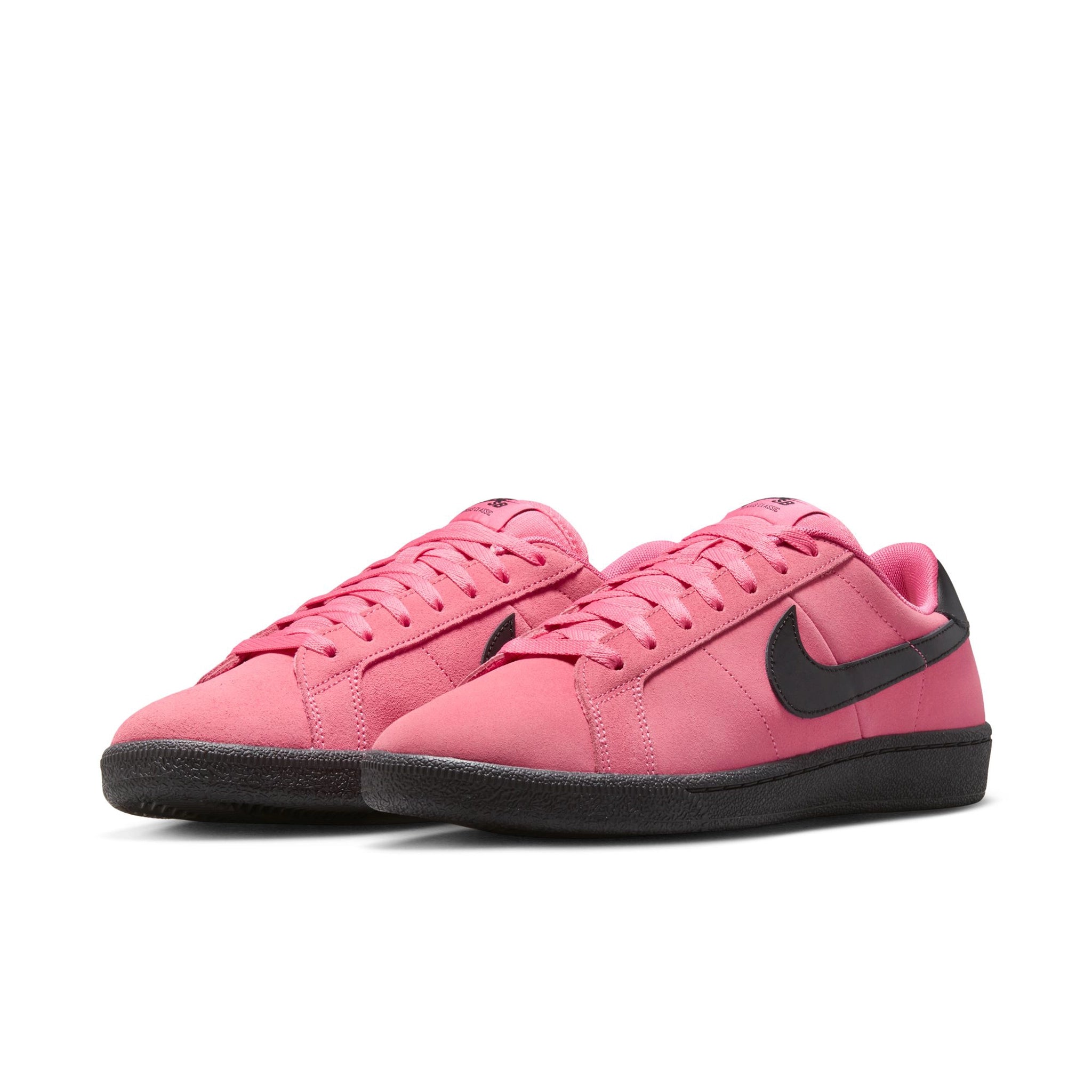 A pair of Hyper Pink Nike SB Zoom Tennis Classic skateboard sneakers with black sole and swoosh branding on a white background