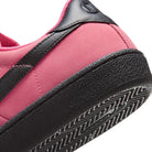 Detail of Hyper Pink Nike SB Zoom Tennis Classic skateboard sneaker with black sole and swoosh branding on a white background