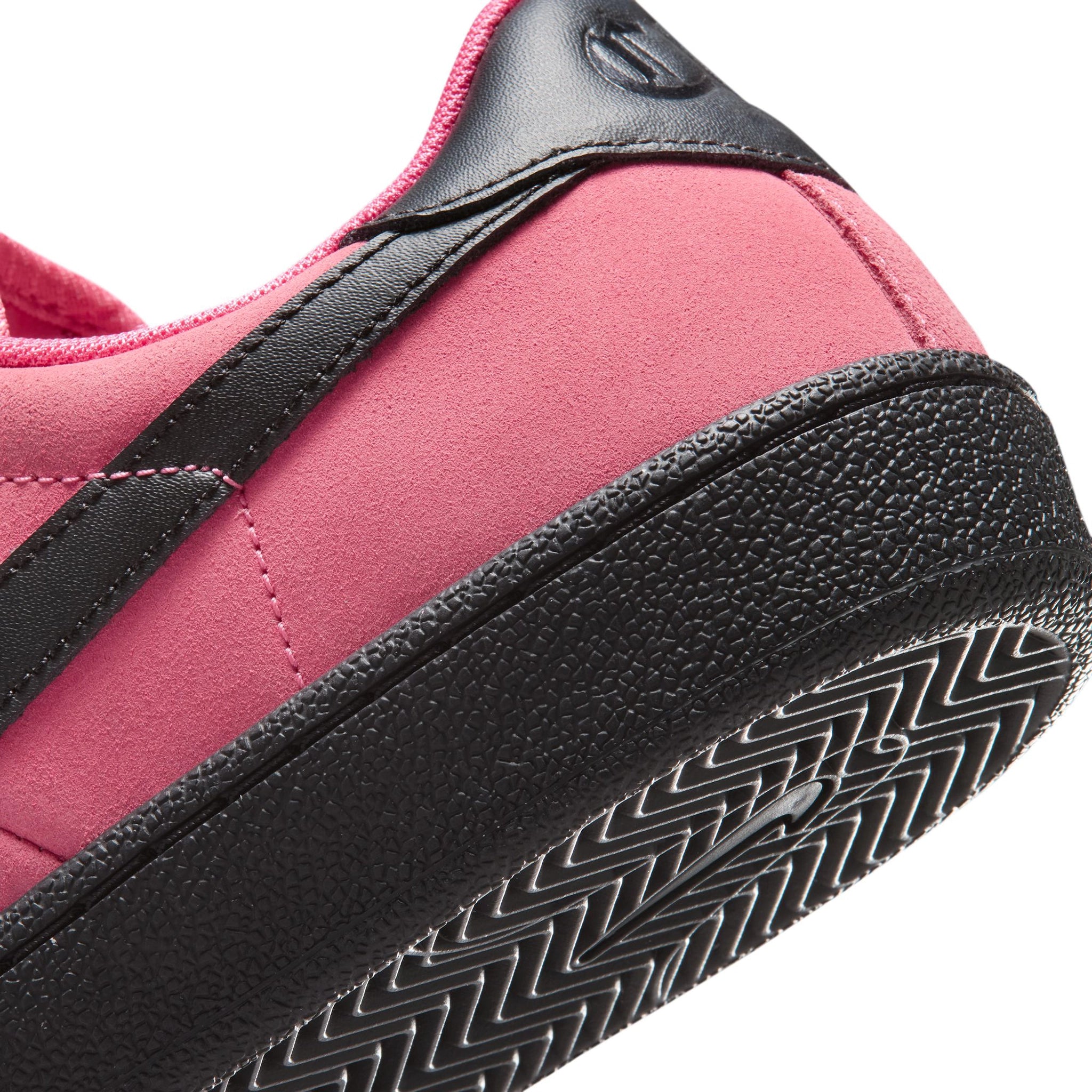 Detail of Hyper Pink Nike SB Zoom Tennis Classic skateboard sneaker with black sole and swoosh branding on a white background