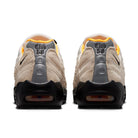 A pair of Sail white Nike SB 'Club 58' Air Max 95 skateboard sneakers with laser orange accents and black sole shown from the back on a white background