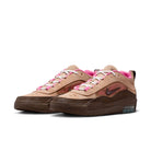 Pair of tan and brown Nike SB Ishod sneakers with pink accents on a white background