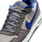 Front of Flint grey Nike SB Paul Rodriguez Zoom Air skateboard sneaker with royal navy swoosh on a white background