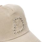 Close up of Taupe Dime MTL Waxed Worker cap with decorative 'D' studs on a white background