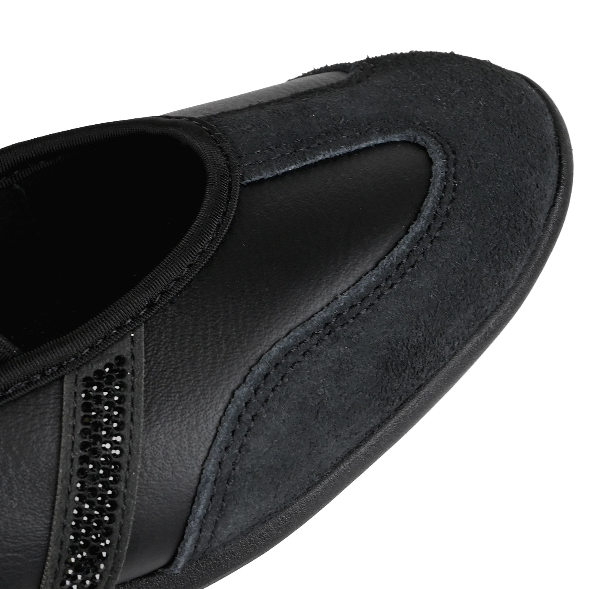 Toe box of a core black Adidas Originals Mary Jane sneaker with textured leather and suede panels, three rhinestone-embellished stripes on a white background.