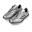 A pair of silver metallic Adidas x Metalwood MC70 golf shoes with gray stripes on a white background