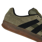 Close up of Olive Strata adidas Skateboarding Mark Gonzales pro model Aloha Super skateboard sneaker with core black stripes on a white background