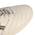 Toe box of Birch Asics Skateboarding Leggerezza Pro FB skateboard sneaker with Loden Green 'Onitsuka' branding on a white background