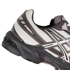 Detail of Oatmeal and obsidian grey Asics Sportstyle GEL-1130 men's lifestyle sneaker with 'Onitsuka' branding on a white background