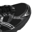 Toe box of Black ASICS Sportstyle GEL-1130 with pure silver sneaker 'Onitsuka' branding on a white background