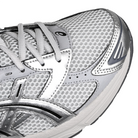 Toe box of Glacier grey and pure silver ASICS sportstyle GEL-1130 sneaker with 'Onitsuka' branding on a white background