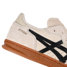 Detail of Oatmeal and black Asics Sportstyle Skyhand OG lifestyle sneaker with 'Onitsuka' branding on a white background