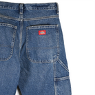 Close-up of Dickies blue denim pants with a red label on a white background