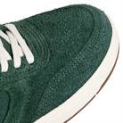 A close up of Emerica Skateboarding KSL III green sneakers with white laces on a white background