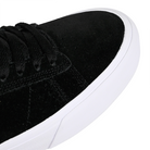 Close-up of an Emerica Skateboarding black sneaker with white sole on a white background