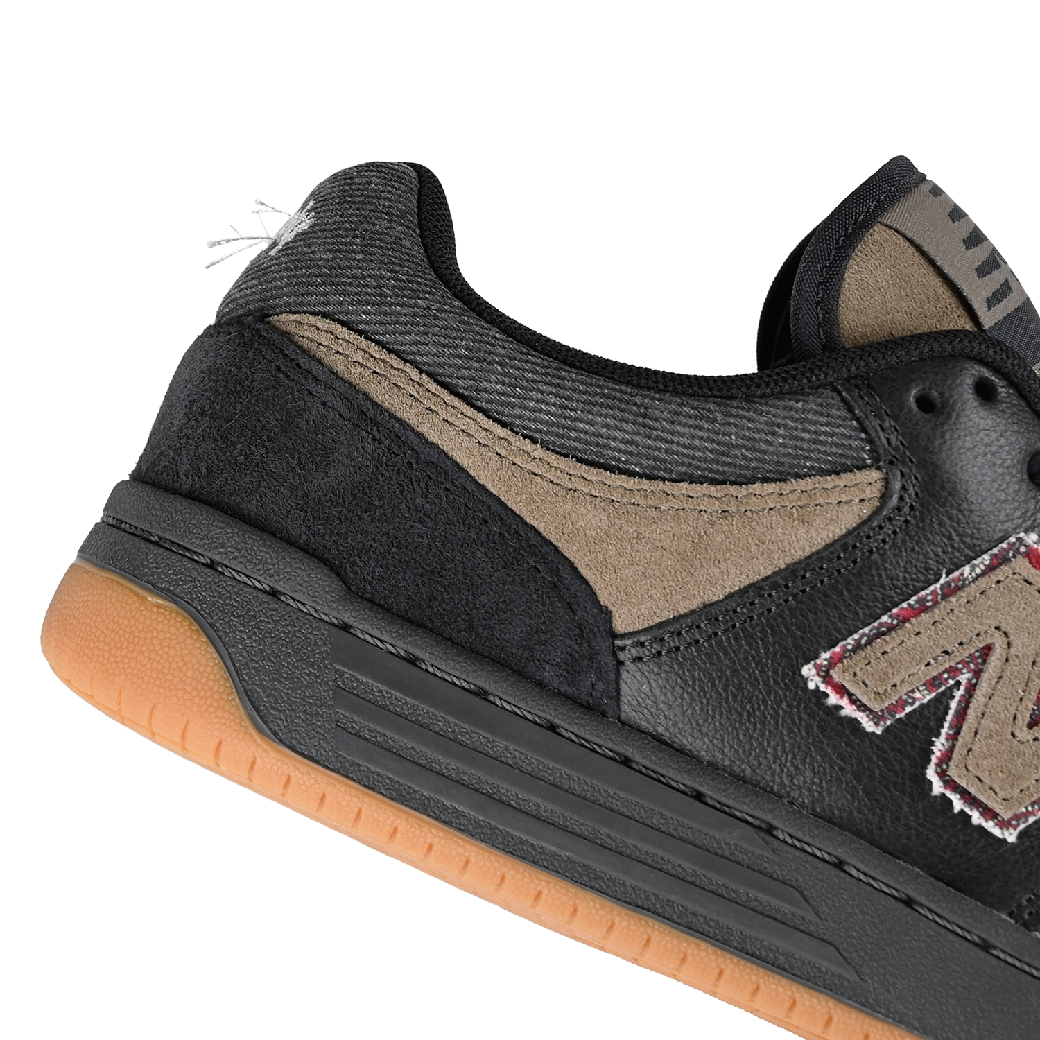 Close up of Black and arid stone New Balance Numeric x No-Comply NM480 skateboard sneaker with a denim heel collar on a white background
