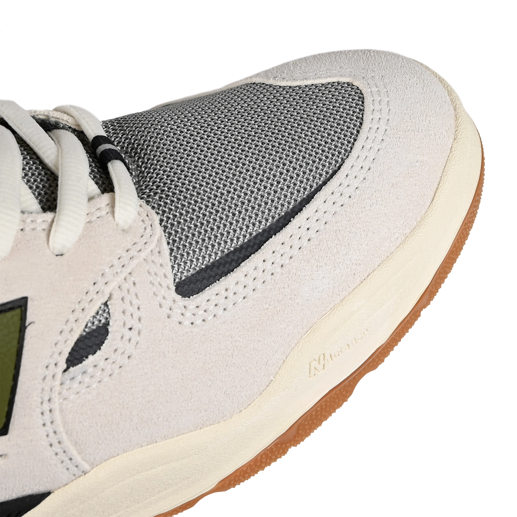 Toe box of Sea Salt New Balance Numeric NM1010 Tiago Lemos pro model skateboard sneaker with Dark Olivine branding on a white background