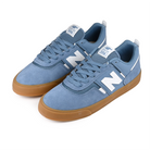 A pair of Heron blue New Balance NM306 Jamie Foy pro model skateboard sneakers with gum sole and white branding on a white background