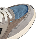 Close up of New Balance Andrew Reynolds NM933 sneaker in gray and blue with New Balance logo on a white background