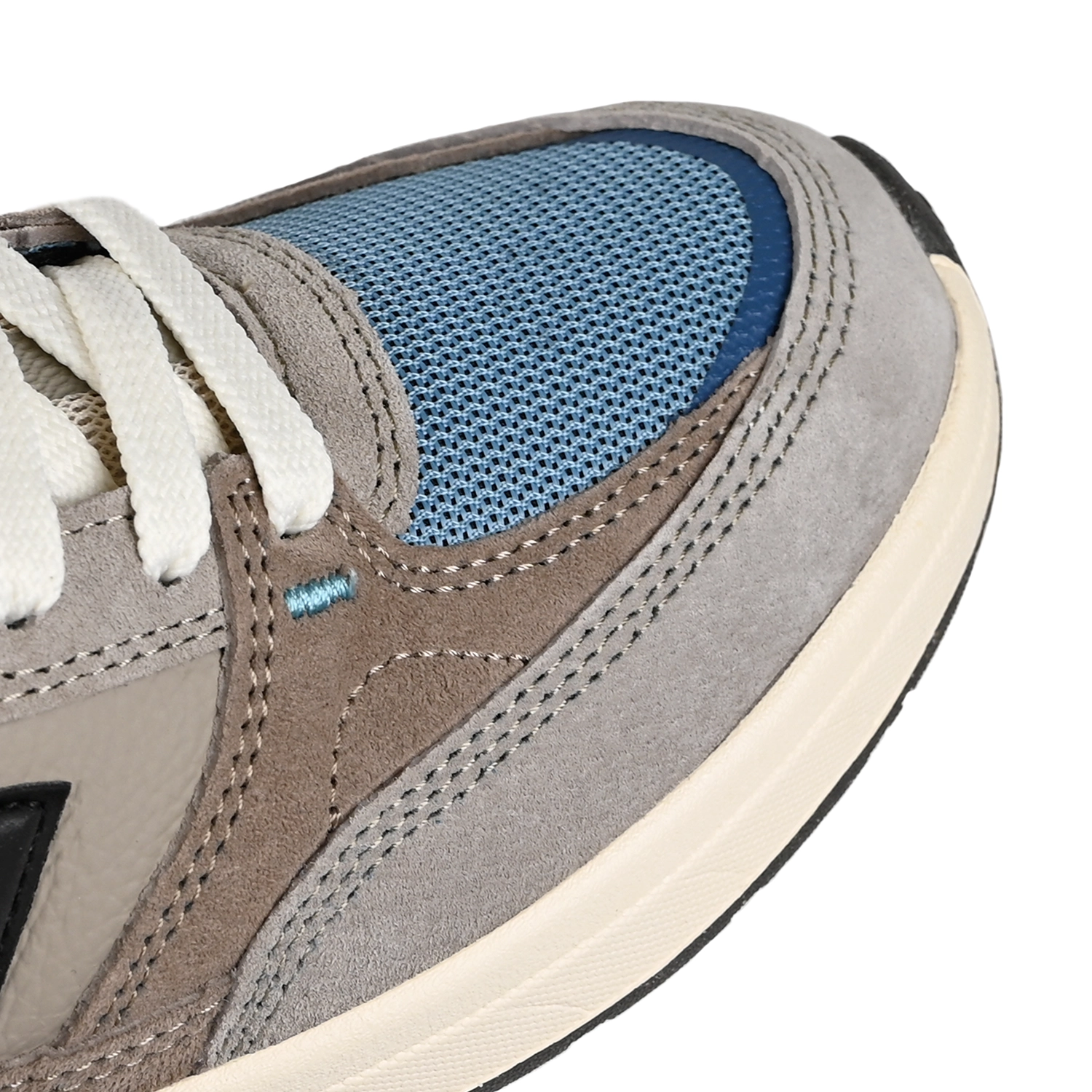 Close up of New Balance Andrew Reynolds NM933 sneaker in gray and blue with New Balance logo on a white background