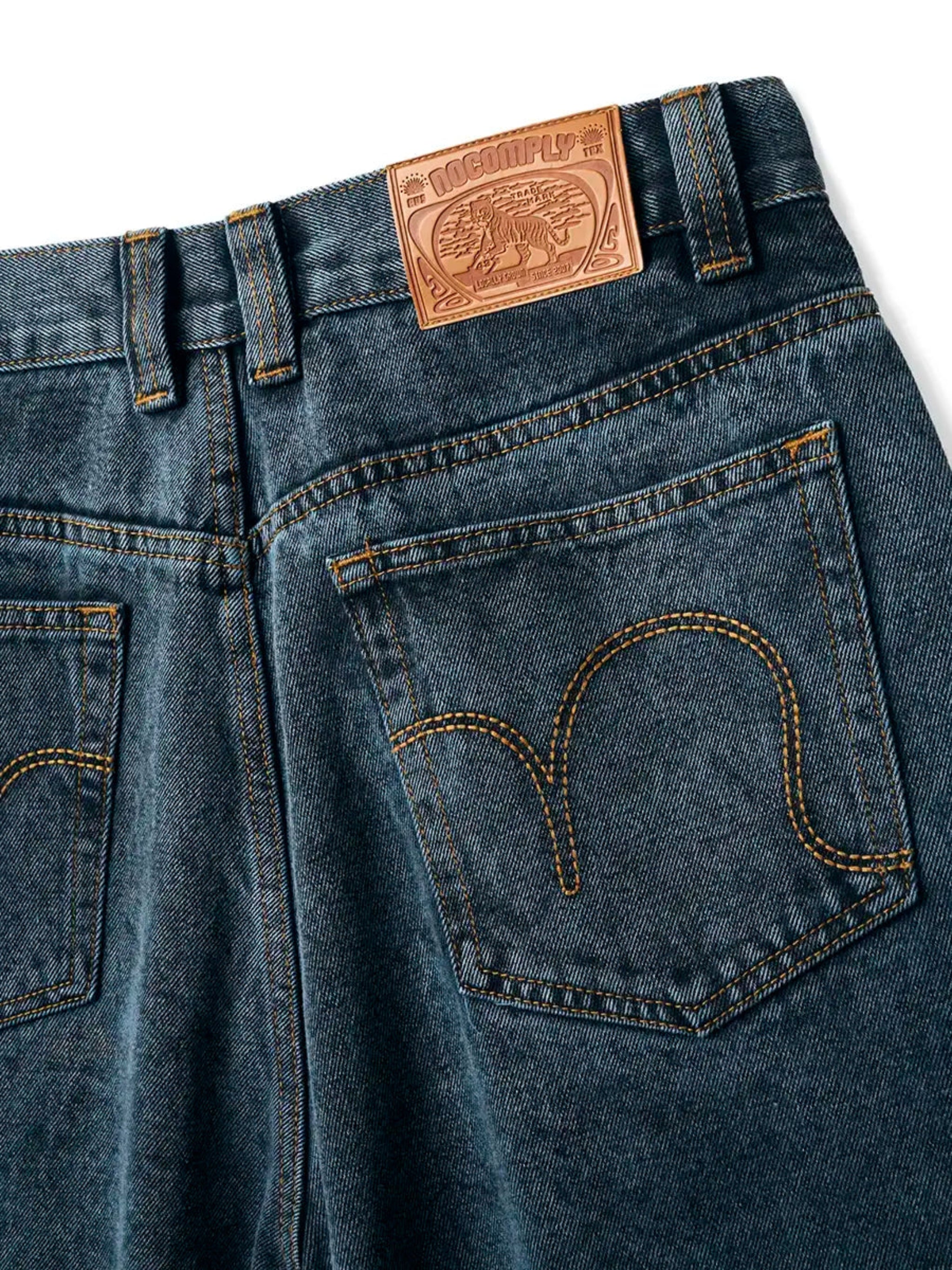 Close up back view of Teal Wash No-Comply Loose Fit denim jeans on a white background