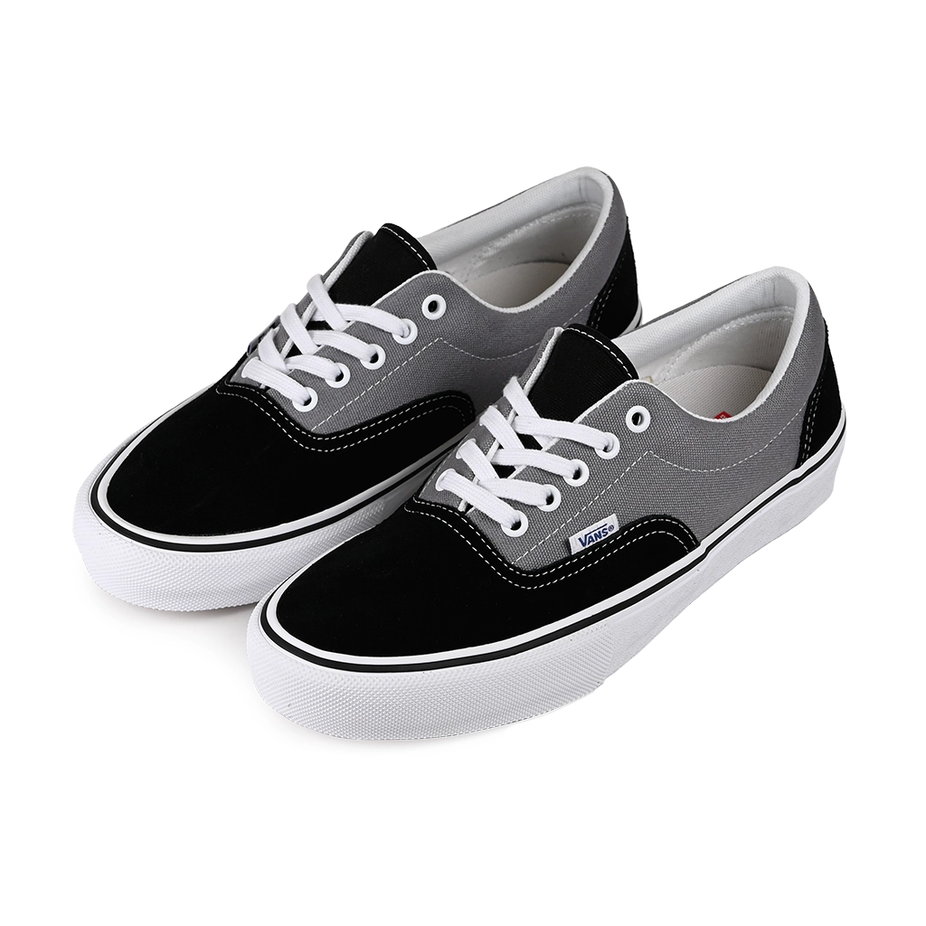 A pair of Vans Skateboarding black and gray Era sneakers with white laces on a white background