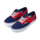 A pair of red and blue Vans Skateboarding Era sneakers with white laces on a white background